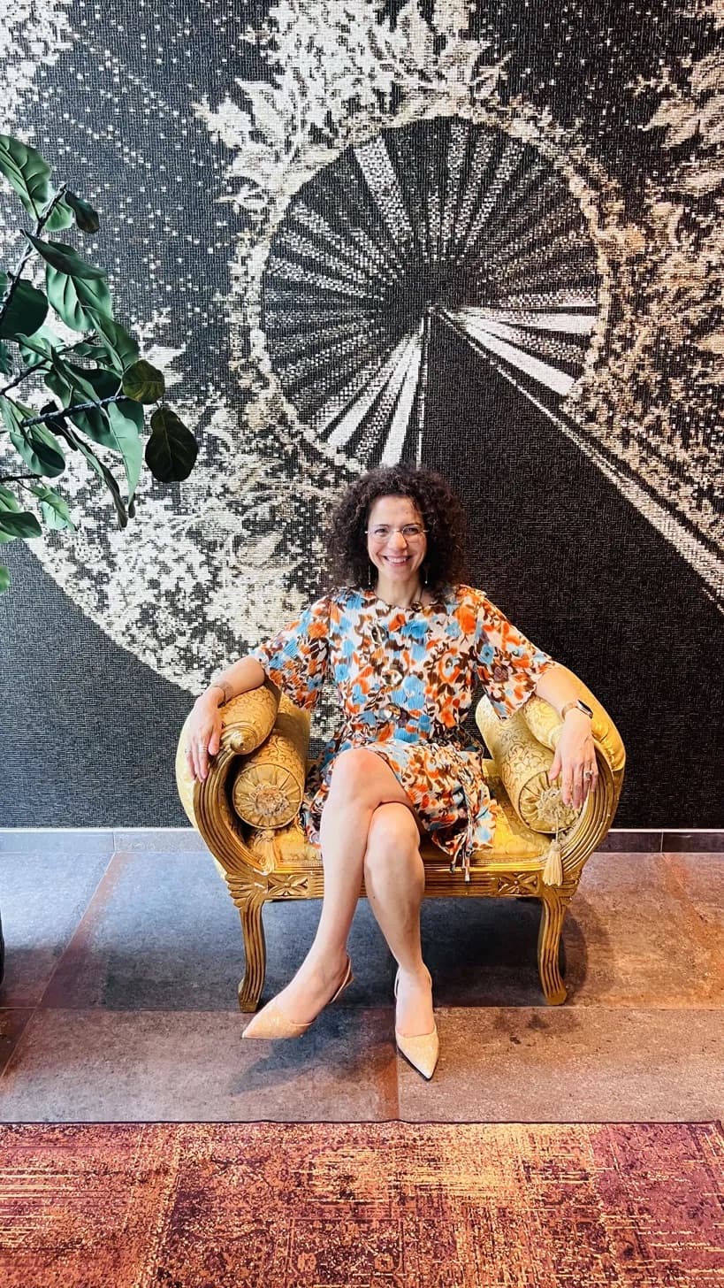 Hanane Risayindi, consultante en communication stratégique et fondatrice de Websait, assise dans un fauteuil doré